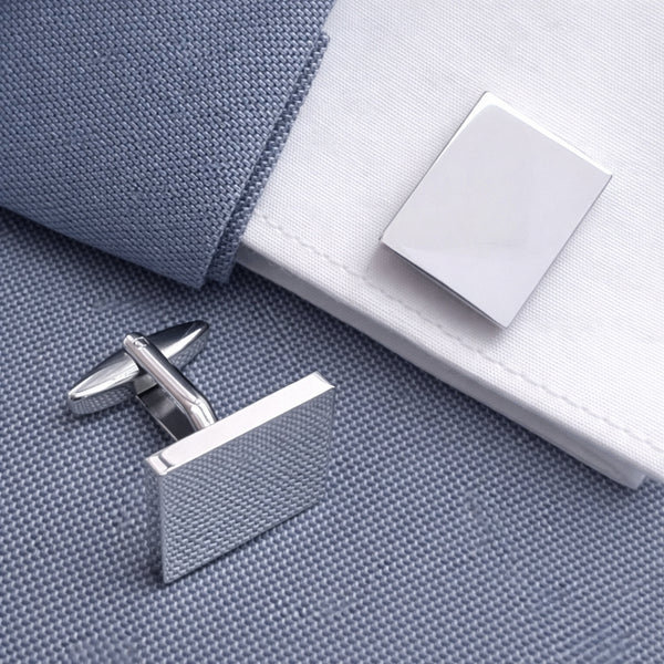 Rechthoekige glanzende manchetknopen gedragen op colbert en overhemd met manchetten